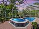 Relaxing screened-in pool and spa area with tile accents and tropical plants at 5140 Windward Ave, Sarasota, FL 34242