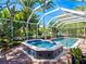 Screened-in pool and spa with surrounding patio at 5140 Windward Ave, Sarasota, FL 34242