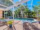 Relaxing pool and spa area with lounge chairs and covered patio at 5140 Windward Ave, Sarasota, FL 34242