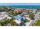 Aerial view of a two-story house near the beach with a pier in the background at 518 Spring Ave, Anna Maria, FL 34216