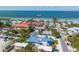 Aerial view of a two-story house near the beach with a pier in the background at 518 Spring Ave, Anna Maria, FL 34216