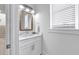 Small bathroom with white vanity and a stylish mirror at 518 Spring Ave, Anna Maria, FL 34216
