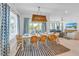 Bright dining room with a large table, wicker chairs, and blue patterned curtains at 518 Spring Ave, Anna Maria, FL 34216