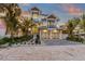 Two-story house with light blue metal roof, two-car garage, and landscaped yard at 518 Spring Ave, Anna Maria, FL 34216