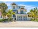 Two-story house with light blue metal roof, two-car garage, and palm trees at 518 Spring Ave, Anna Maria, FL 34216