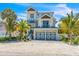 Two-story house with light blue metal roof, two-car garage, and landscaped yard at 518 Spring Ave, Anna Maria, FL 34216