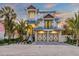 Two-story house with a light blue metal roof, two-car garage, and landscaped yard at 518 Spring Ave, Anna Maria, FL 34216