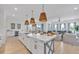 Spacious kitchen with white cabinets, a large island, and wicker pendant lights at 518 Spring Ave, Anna Maria, FL 34216