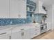 White kitchen with blue mosaic backsplash and quartz countertops at 518 Spring Ave, Anna Maria, FL 34216