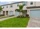 Townhome with light-colored exterior, landscaping, and attached garage at 5447 Tripoli Dr, Palmetto, FL 34221