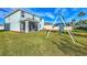 Green grassy backyard with swing set and home at 5755 Woodland Sage Dr, Sarasota, FL 34238