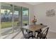 Dining area with wooden table, black chairs, and sliding glass doors to backyard at 5755 Woodland Sage Dr, Sarasota, FL 34238