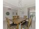 Bright dining area with wooden table and chairs, view of kitchen at 5755 Woodland Sage Dr, Sarasota, FL 34238