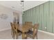 Dining room with wooden table and chairs, green accent wall at 5755 Woodland Sage Dr, Sarasota, FL 34238