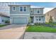Two-story house with light teal siding, stone accents, and a two-car garage at 5755 Woodland Sage Dr, Sarasota, FL 34238