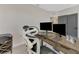 Bright home office features a large desk with dual monitors and comfortable chair at 5755 Woodland Sage Dr, Sarasota, FL 34238