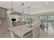 Open concept kitchen with island, stainless steel appliances, and dining area at 5755 Woodland Sage Dr, Sarasota, FL 34238