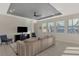 Spacious living room with tile floors, large windows, and a ceiling fan at 5755 Woodland Sage Dr, Sarasota, FL 34238