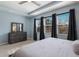 Bright main bedroom features a king-size bed, dresser, and large windows at 5817 Hevena Ct, Palmetto, FL 34221