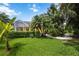 Landscaped backyard, featuring a stone path and lush tropical foliage at 7596 Palmer Glen Cir, Sarasota, FL 34240