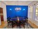Elegant dining room with a blue accent wall and a stylish chandelier at 7596 Palmer Glen Cir, Sarasota, FL 34240