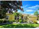 Beautiful yellow home with lush landscaping and a tile driveway at 7596 Palmer Glen Cir, Sarasota, FL 34240
