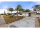 Front view of a white single story home with palm trees and a paved driveway at 8142 Coco Solo Ave, North Port, FL 34287