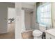 Clean bathroom with shower/tub combo, toilet, and a window at 9008 Allapata Ln, Venice, FL 34293