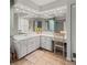 Double vanity bathroom with lighted mirrors and a makeup vanity at 9008 Allapata Ln, Venice, FL 34293