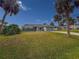 Single story home with a gray garage door and palm trees at 9008 Allapata Ln, Venice, FL 34293