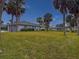 Single-Gathering home with a large grassy yard and palm trees at 9008 Allapata Ln, Venice, FL 34293