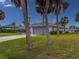 House exterior showcasing a gray garage door and palm trees at 9008 Allapata Ln, Venice, FL 34293