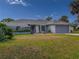 Single-Gathering home with a gray garage door and palm trees at 9008 Allapata Ln, Venice, FL 34293