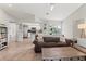 Open living room features a brown couch, coffee table, and views into the kitchen at 9008 Allapata Ln, Venice, FL 34293