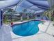 Enclosed pool with patio furniture and tropical plants at 9008 Allapata Ln, Venice, FL 34293