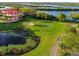 Aerial view of golf course, waterfront homes, and lush landscaping at 9435 Discovery Ter # 202D, Bradenton, FL 34212
