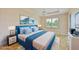 Virtually staged bedroom with light wood floors and blue bedding at 9435 Discovery Ter # 202D, Bradenton, FL 34212