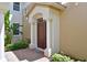 Inviting front door entry with brick walkway, lush landscaping, and columns at 9435 Discovery Ter # 202D, Bradenton, FL 34212