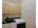Laundry room with upper cabinets and newer washer/dryer at 9435 Discovery Ter # 202D, Bradenton, FL 34212