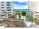 Relaxing balcony with lounge chairs and water view at 111 Golden Gate Pt # 401, Sarasota, FL 34236