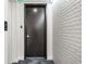 Modern hallway with dark door and textured wall at 111 Golden Gate Pt # 401, Sarasota, FL 34236