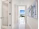 Bright hallway with water views and modern art at 111 Golden Gate Pt # 401, Sarasota, FL 34236