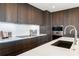 Modern kitchen featuring dark wood cabinets and stainless steel appliances at 111 Golden Gate Pt # 401, Sarasota, FL 34236