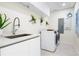 Modern laundry room with white cabinets and sink at 111 Golden Gate Pt # 401, Sarasota, FL 34236