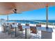 Enjoy breathtaking water views from this rooftop terrace with seating and a ceiling fan at 111 Golden Gate Pt # 401, Sarasota, FL 34236