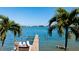 Wooden dock extending over calm water with palm trees and boats in the background at 117 10Th N St # 122, Bradenton Beach, FL 34217