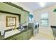 Green laundry room with washer, dryer, and sink at 11740 Rive Isle Run, Parrish, FL 34219