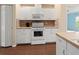 White kitchen cabinets, laminate flooring, and modern appliances at 1204 W 20Th Ave, Palmetto, FL 34221