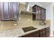 Kitchen features a gas cooktop, stainless steel range hood, and granite countertops at 12941 Bliss Loop, Bradenton, FL 34211