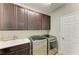 Laundry room with dark brown cabinets and stainless steel appliances at 12941 Bliss Loop, Bradenton, FL 34211